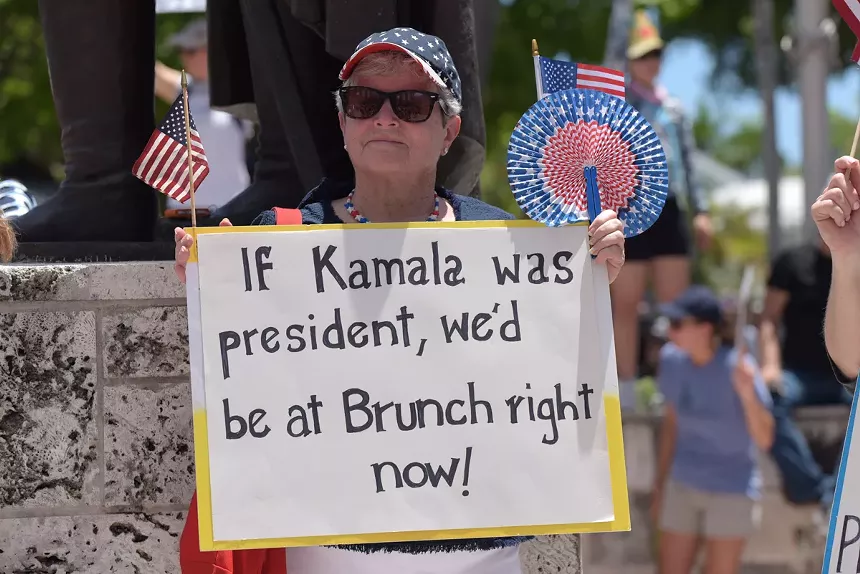 A woman holds a sign implying Kamala Harris was the better choice for president.