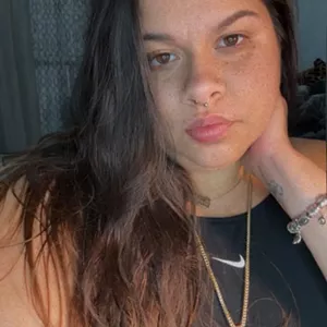 A young woman in a black shirt poses for a selfie