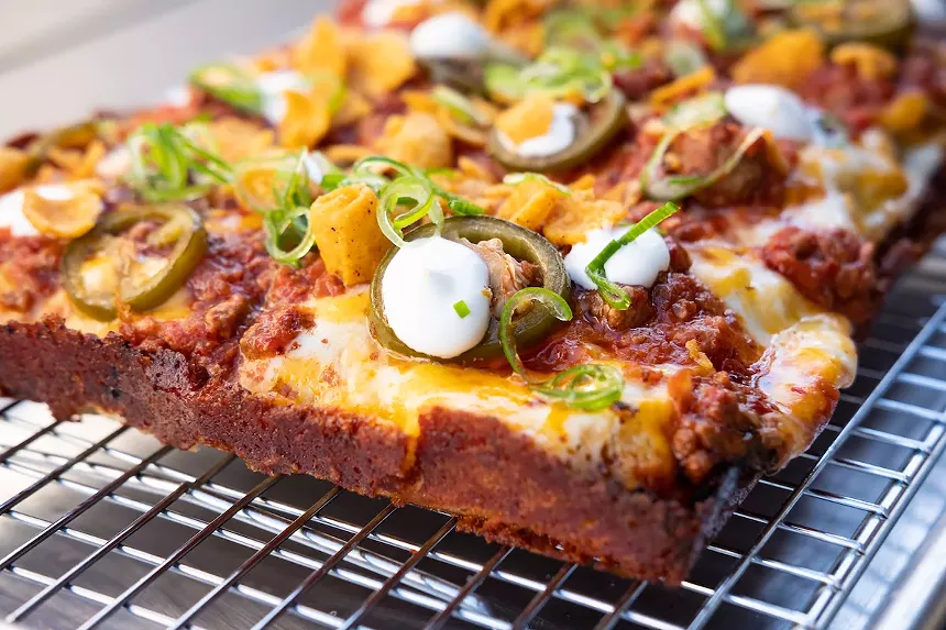 A crispy pizza corner with toppings.