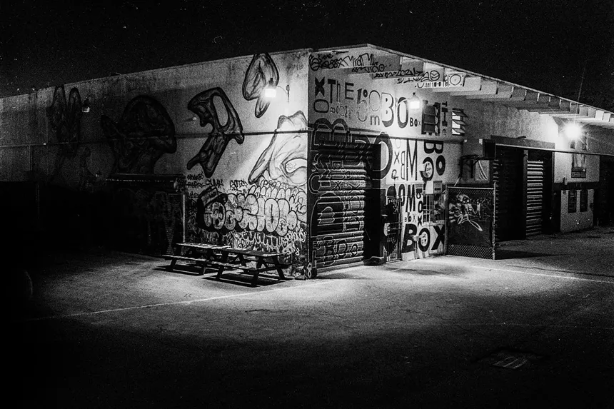 Black and white picture of a venue covered in graffiti.