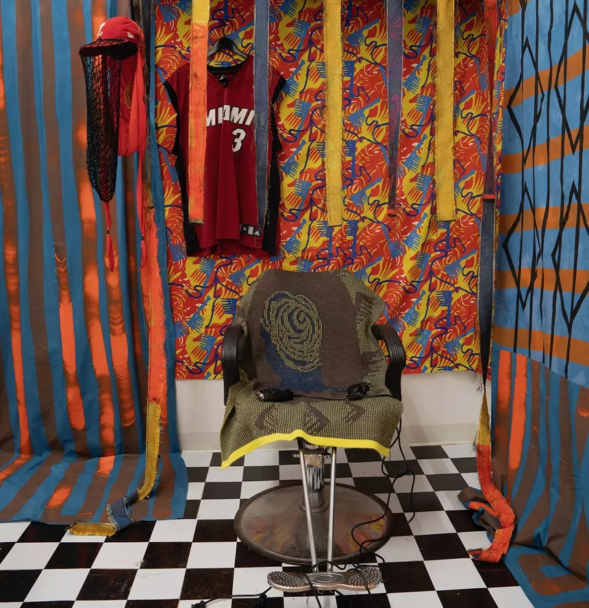 image of Jevon Brown art installation showing textiles behind a barbershop chair