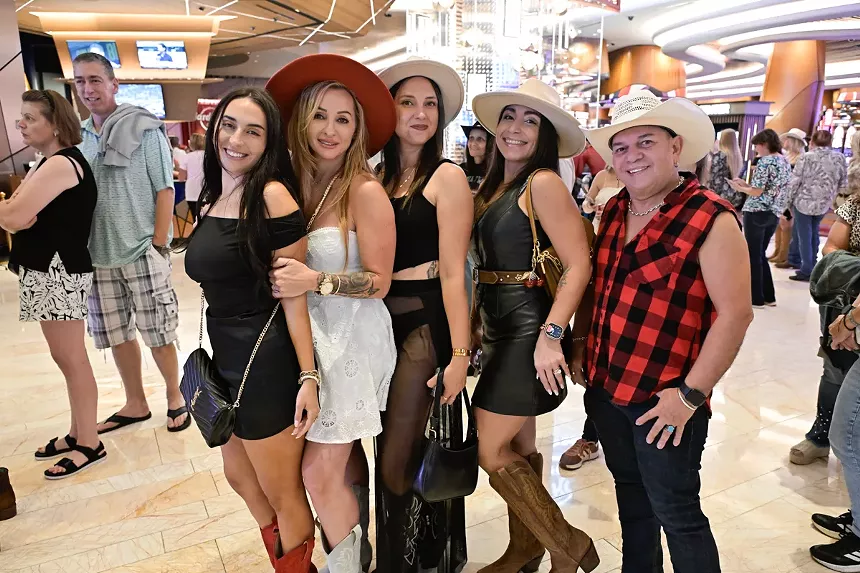A group of people at a concert wearing cowboy-inspired outfits.