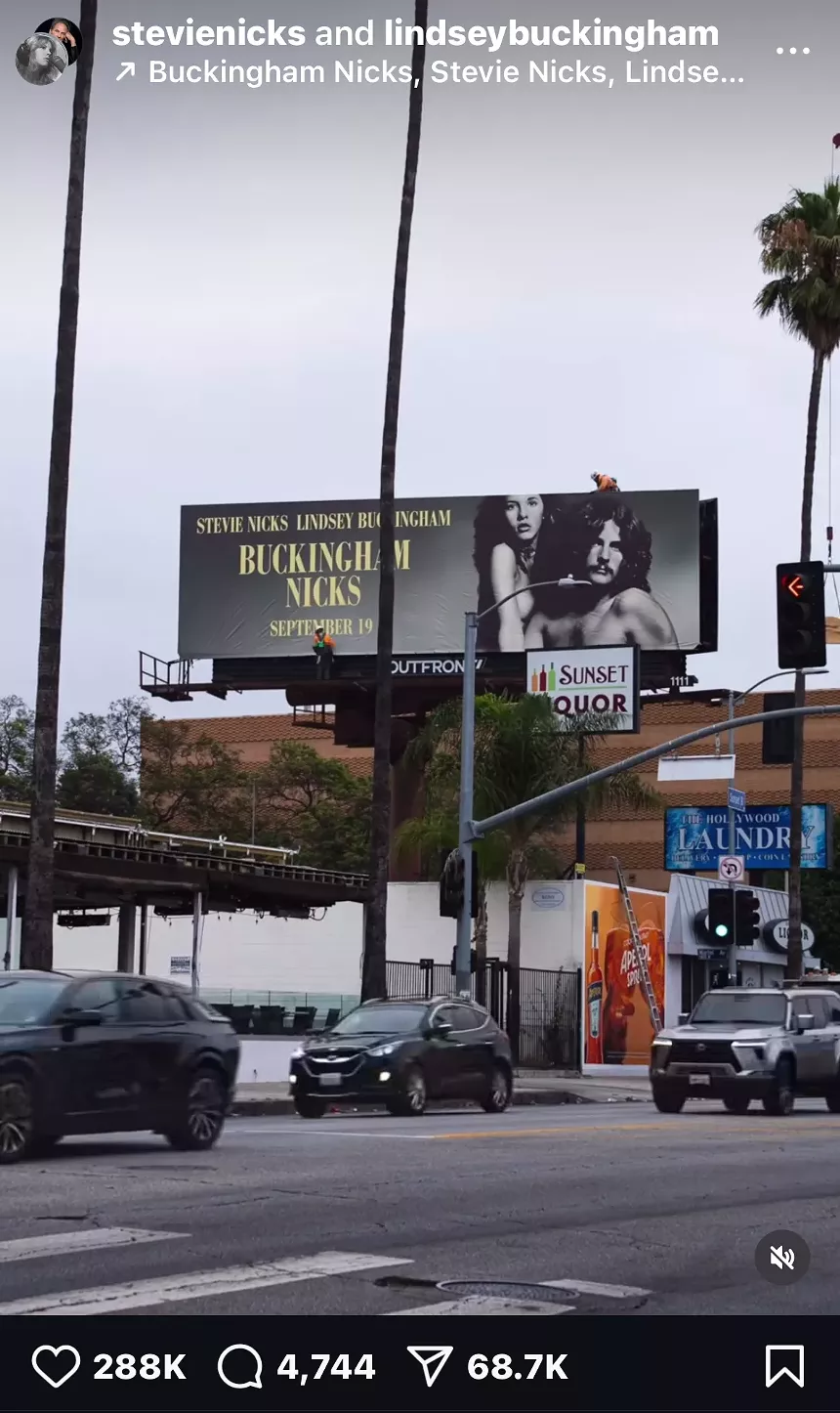 Screenshot of an Instagram reel showing a billboard featuring Stevie Nicks and Lindsey Buckingham.