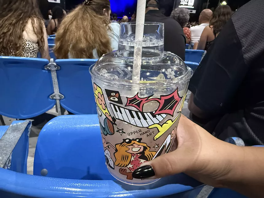 A cup featuring Upper Hand Art's work.