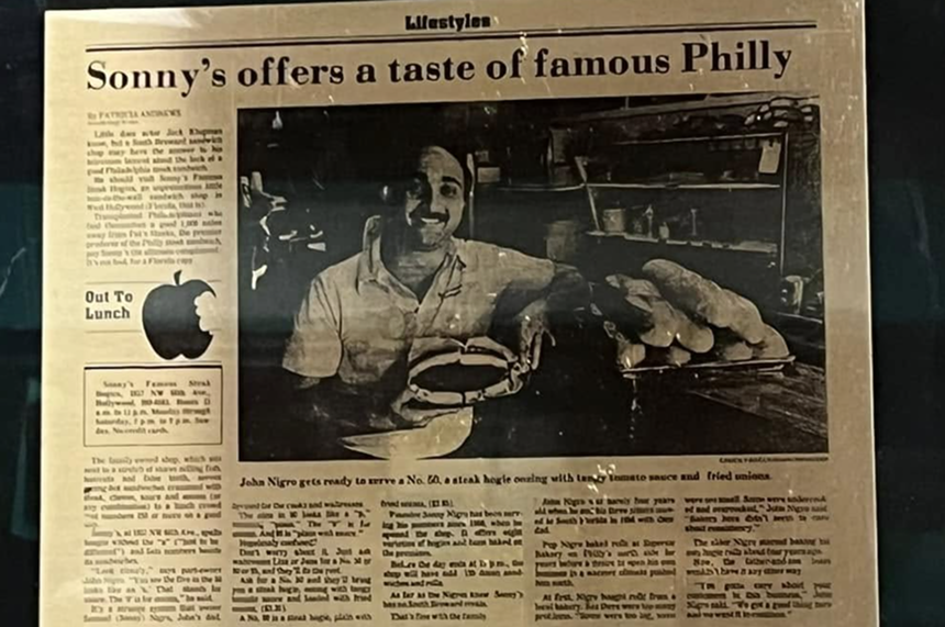 a photo of a print newspaper article framed and hung on a wall inside of a restaurant