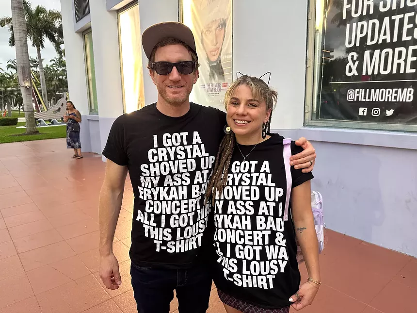 Two concertgoers wearing a limited edition t-shirt from a previous Badu show.
