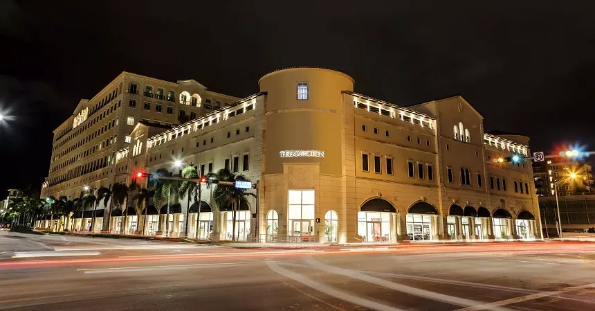 facade of the Collection car dealership lit up at night in Coral Gables, Florida