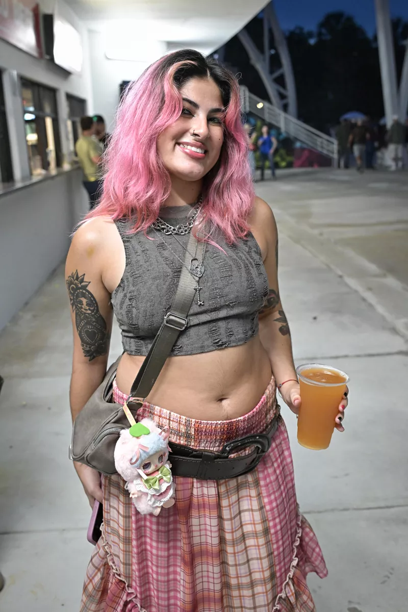 A young woman with pink hair and a labubu