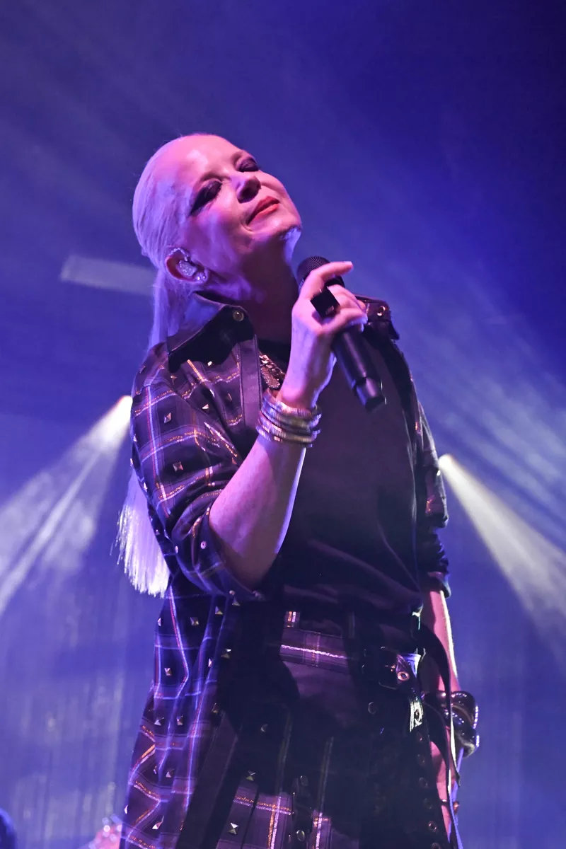 Picture of Shirley Manson with her eyes closed and holding a microphone.