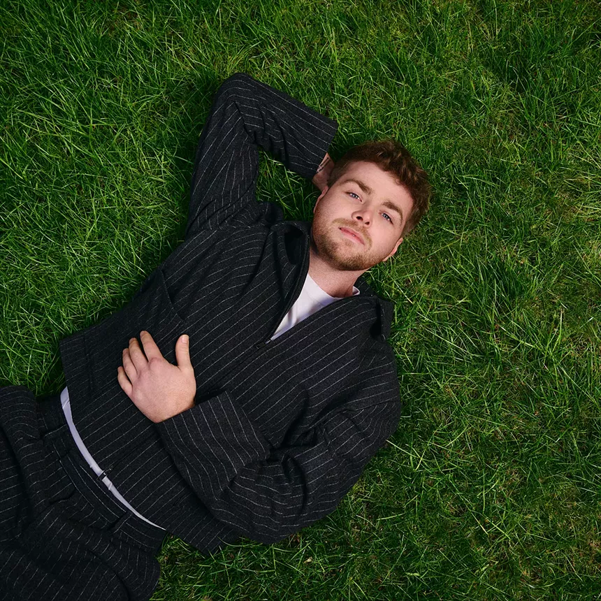 Picture of a young man lying on the grass.