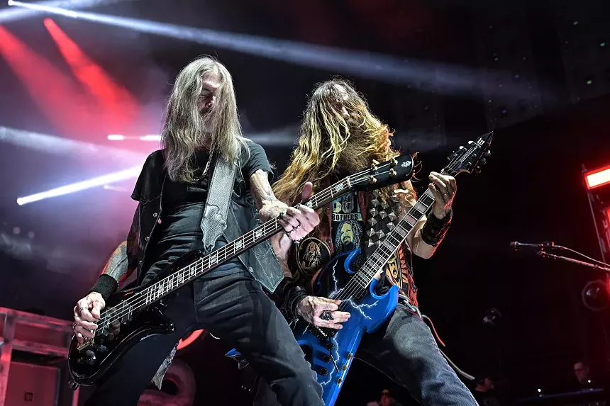 Two heavy metal musicians on stage.