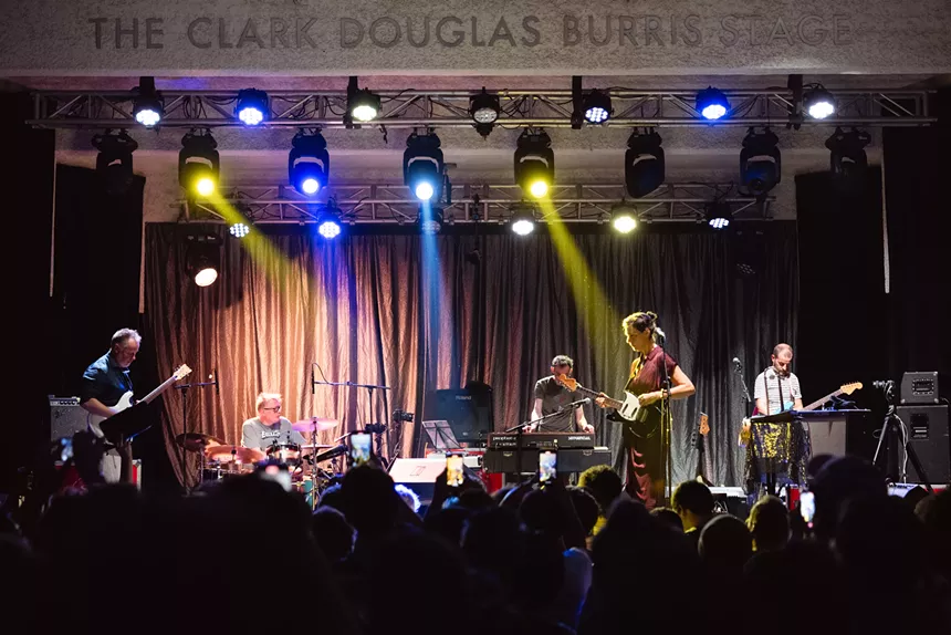 A band performing on stage at a theater.