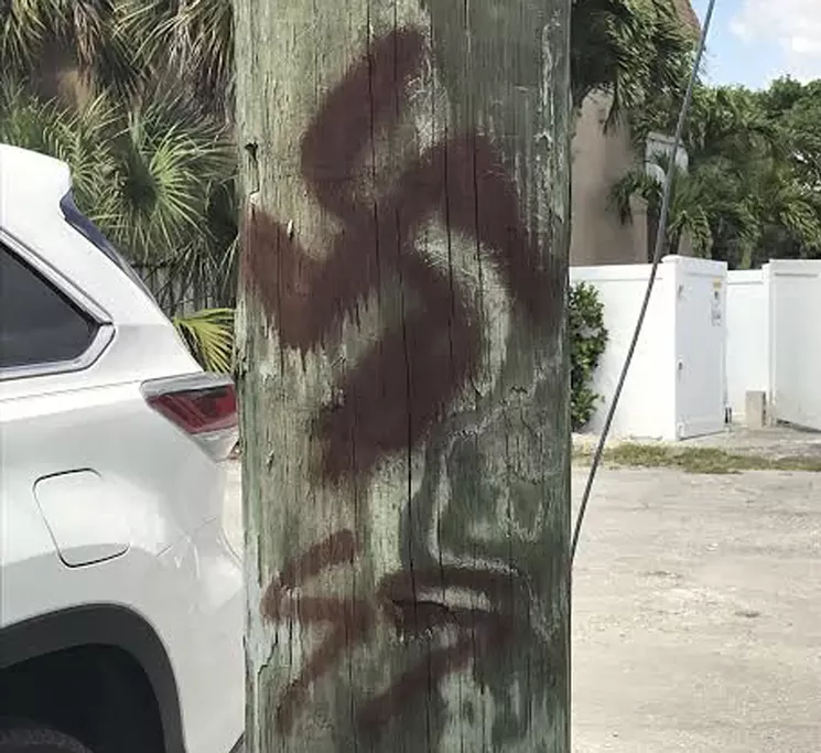 Swastika spray-painted on a telephone pole in Dania Beach are among the bigoted displays captured in ProPublica's database. - PHOTO VIA PROPUBLICA