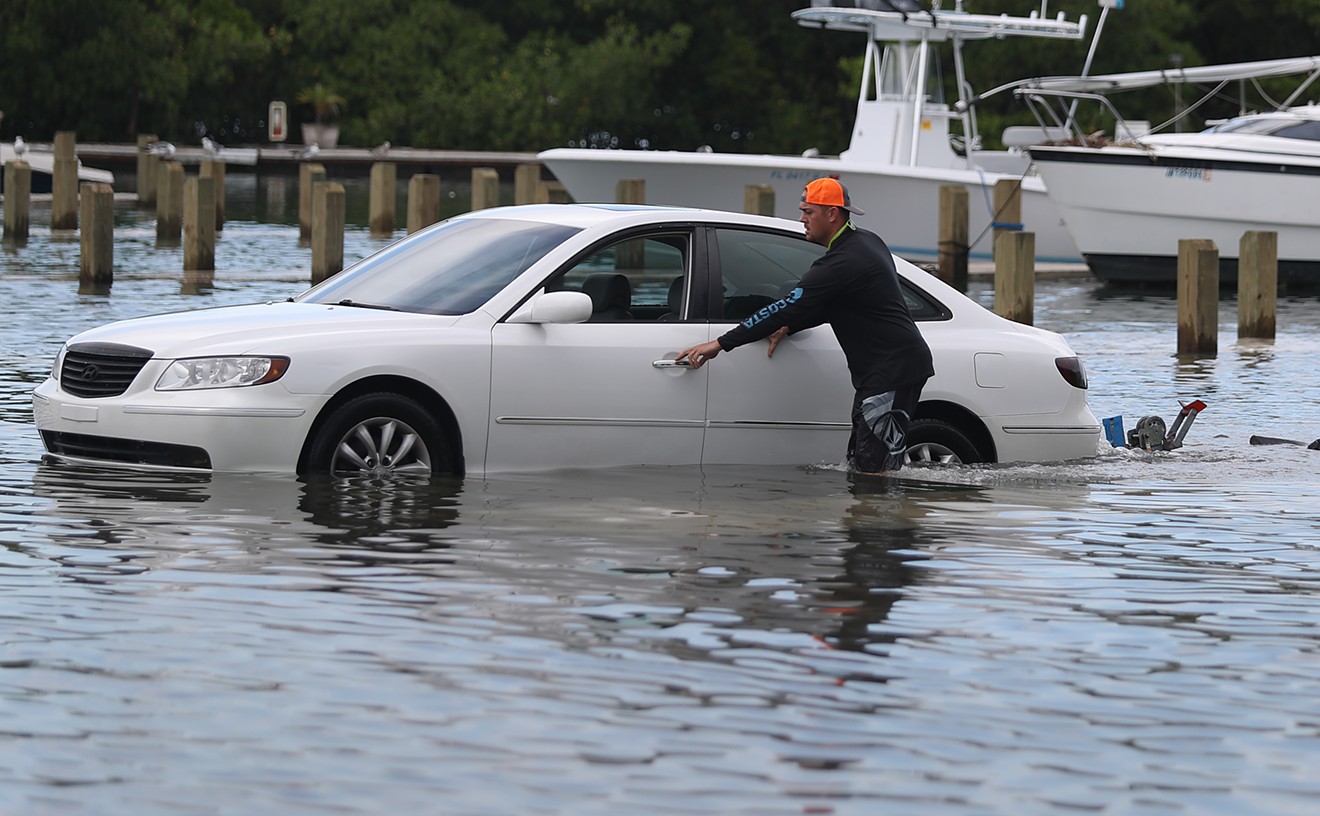 Weston Rice drives through a flooded parking lot at the Haulover Marine Center before the arrival of Hurricane Dorian.
