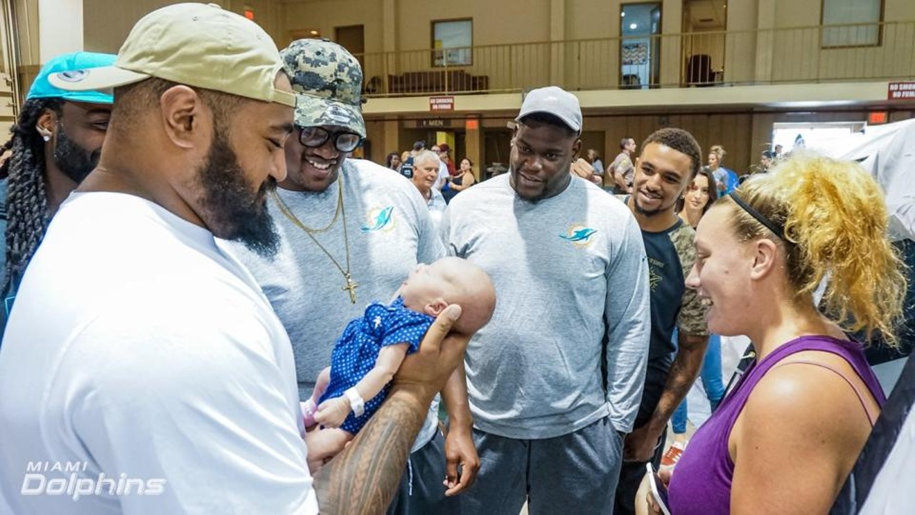 The Dolphins visit a shelter in Miami before Sunday's game in New York.