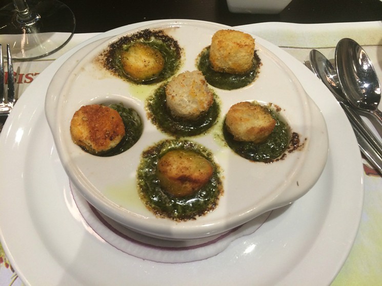 Classically prepared escargots are topped with brioche croutons.