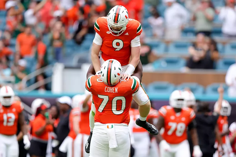 Image: UM players celebrate a touchdown