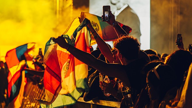 An audience member waves a flag at the Vibra Urbana music festival in Miami