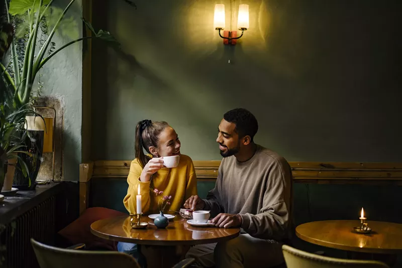 Image: A couple starring at each other in a coffee shop