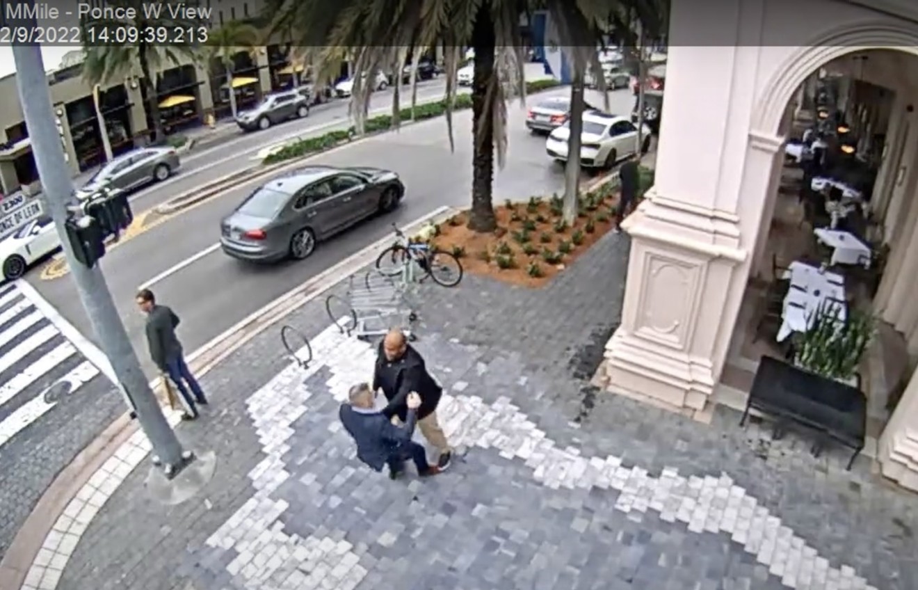 A man identified as Miami police detective Stanley Paul Noel (bald) tussles with Carlos "CJ" Gimenez outside Morton's the Steakhouse in Coral Gables as captured on the city's CCTV footage.