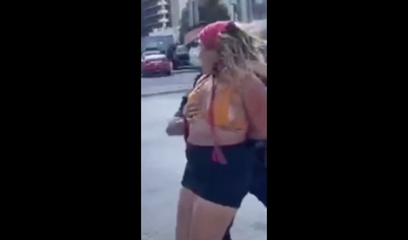A Miami Police Department officer touches a woman's breast while making an arrest Wednesday.