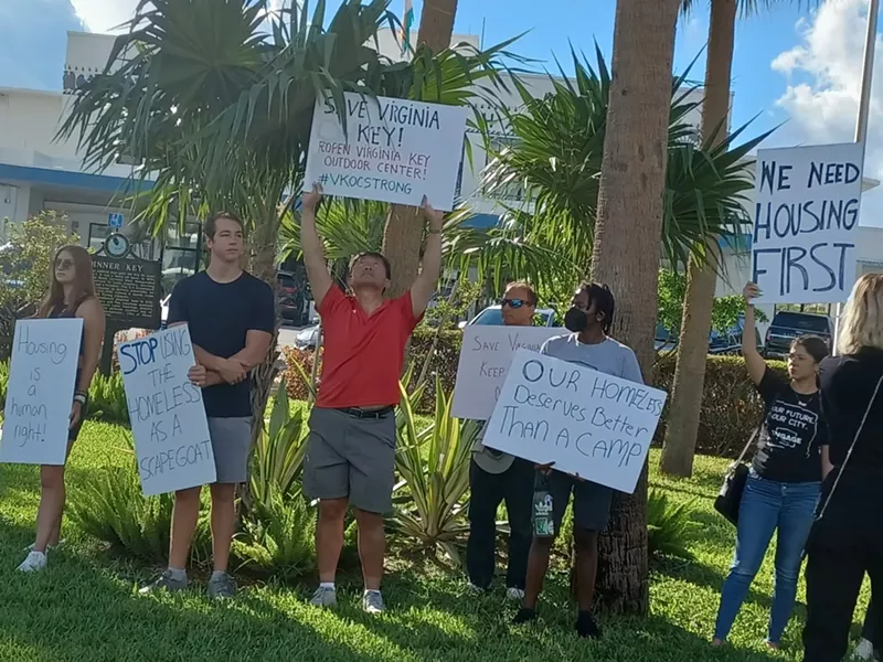 Image: Protesters outside Miami City Hall called for the return of the Virginia Key Outdoor Center and an end to plans for a homeless "tiny house" project on the island.