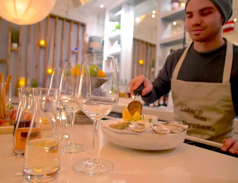 Image: Andrei Situlin shucks fresh oysters in front of guests at Water Lion's 10-seat bar.