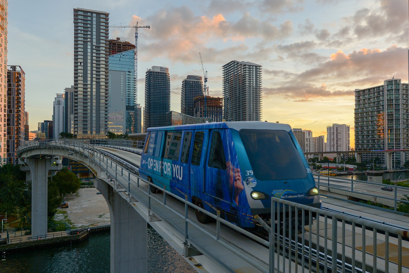 The Brickell skyline at sunset with Metromover over the Miami River
