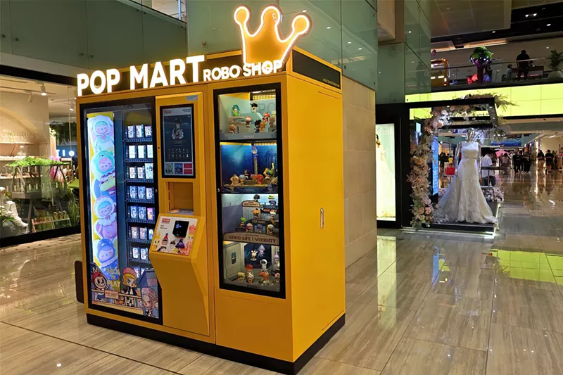 Image: a yellow Pop Mart vending machine inside a mall