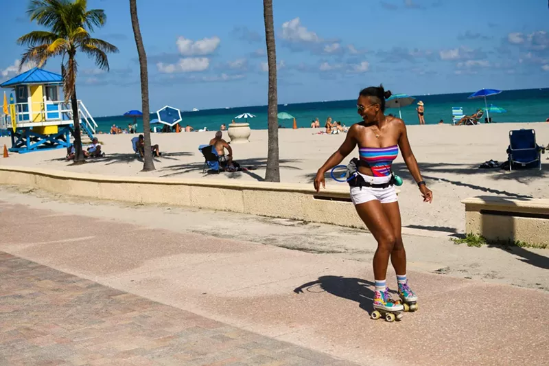 Image: A woman roller-skates on the Hollywood Beach Broadwalk on February 12, 2022.