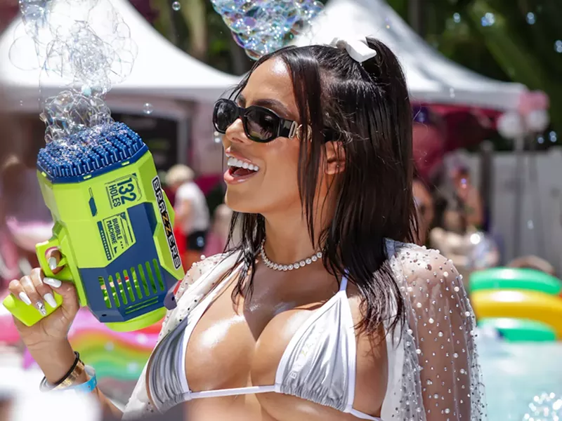 Image: Luna Star holding a bubble gun and wearing a silver bikini